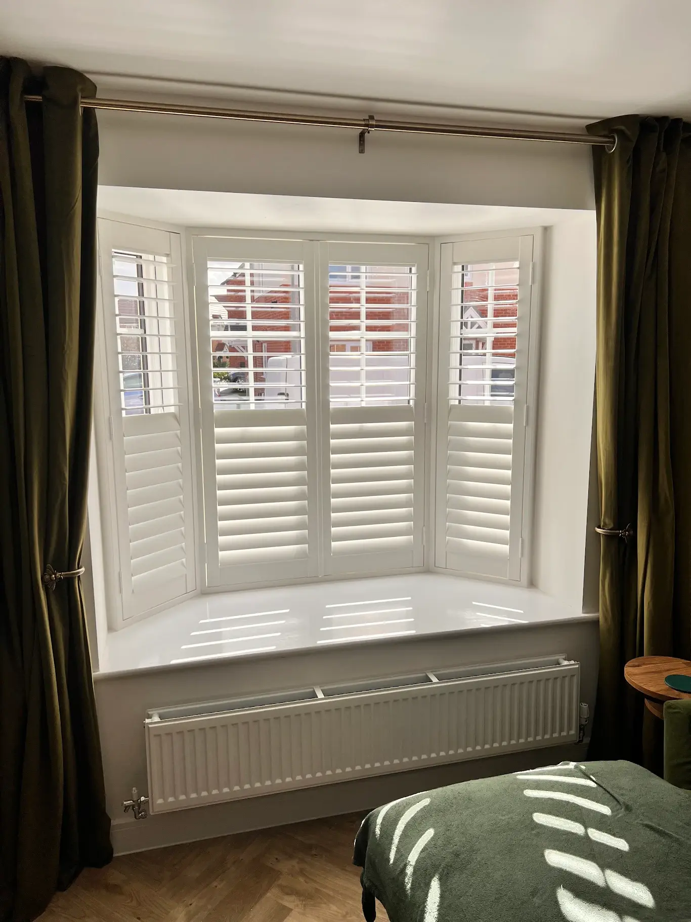 Custom-fitted shutters in a bay window